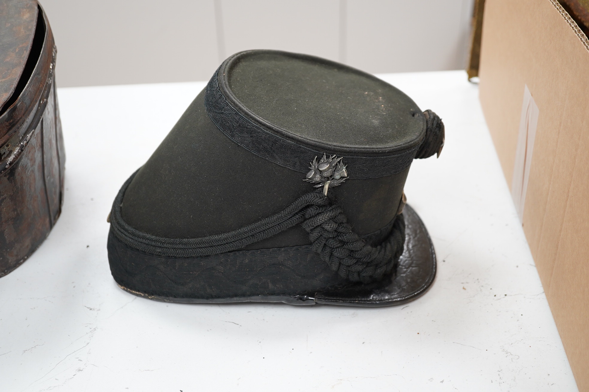 A Victorian tin cased Scottish Rifles officer's shako by Cater & Co. Pall Mall, London, with cap badge for the Cameronians, Applied plaque to lid engraved R. Robertson Esq. 2nd Scottish Rifles. Condition - fair to good,